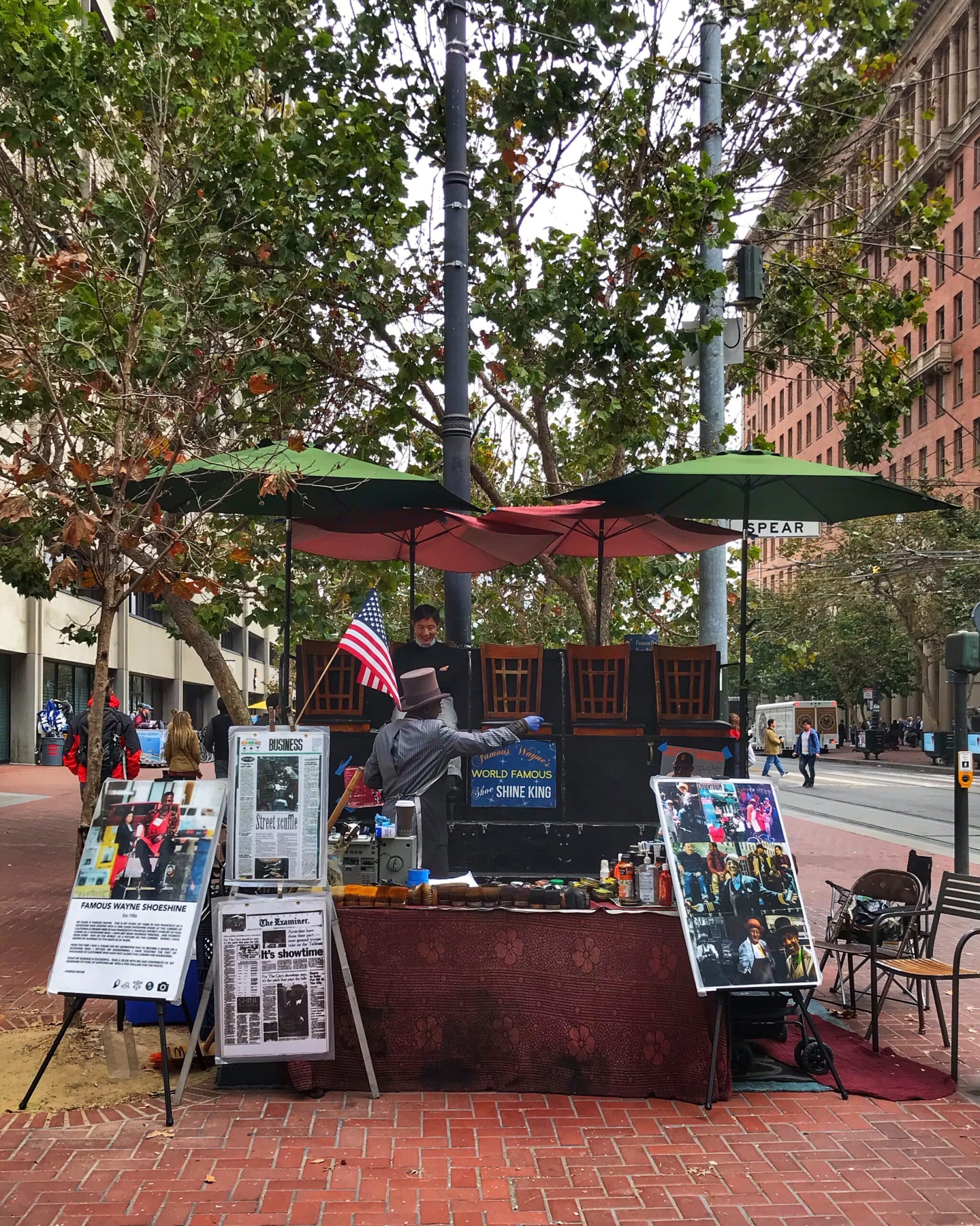 Puesto en medio de la calle en San Francisco con productos a la venta y personas al alrededor, mostrando ambiente urbano y mercado callejero típico de la ciudad