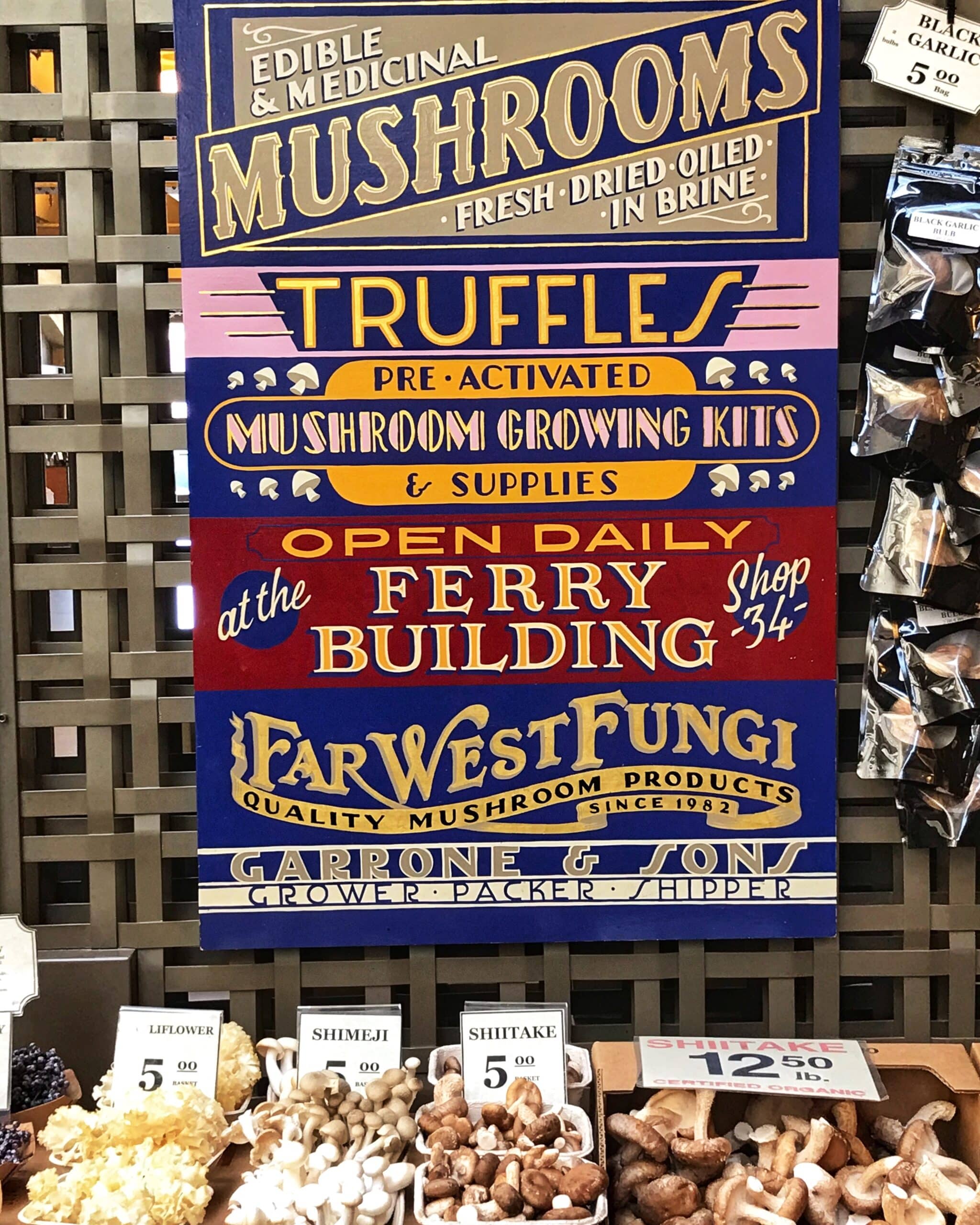 Cartel grande en San Francisco que dice Edible al medical Mushrooms Fresh sobre mesa con variante de champiñones frescos de diferentes tipos, mostrando productos de alimentación saludable