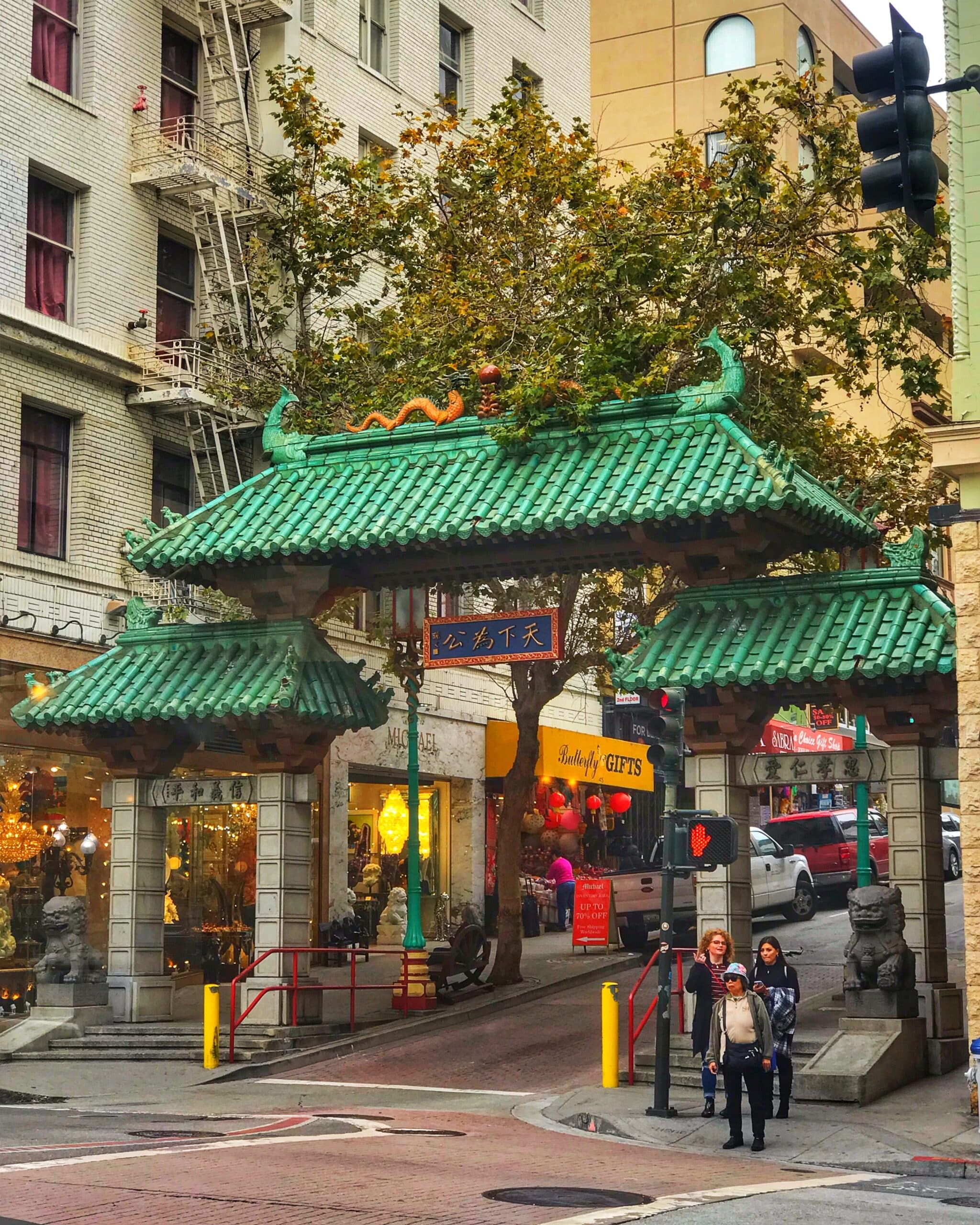 Calle San Francisco con edificio que marca la entrada al barrio chino, rodeada de tiendas y arquitectura característica del distrito chino de la ciudad