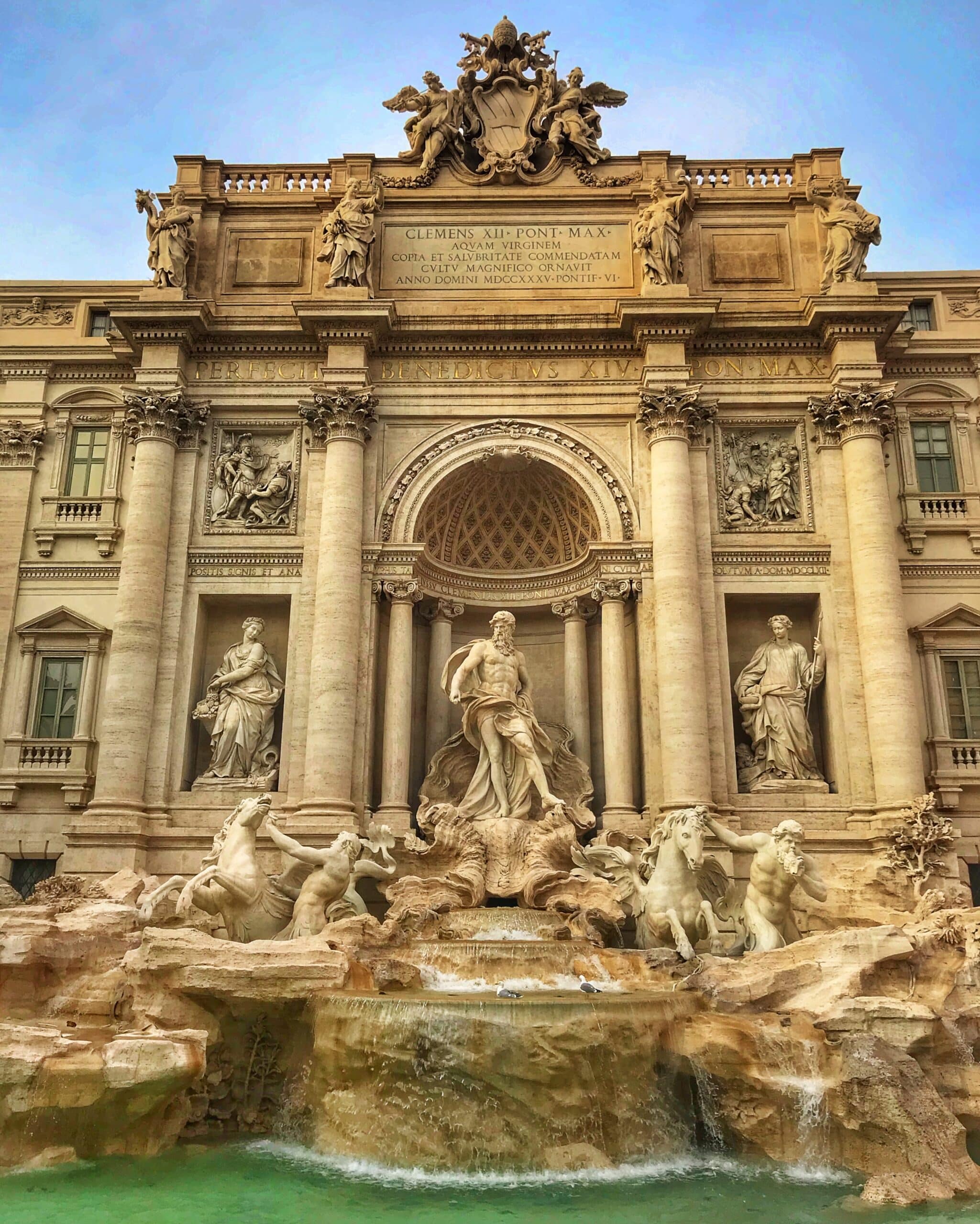 Vista de la fontana de Trevi en Roma mostrando la famosa fuente barroca, esculturas detalladas y el agua cristalina del emblemático monumento italiano