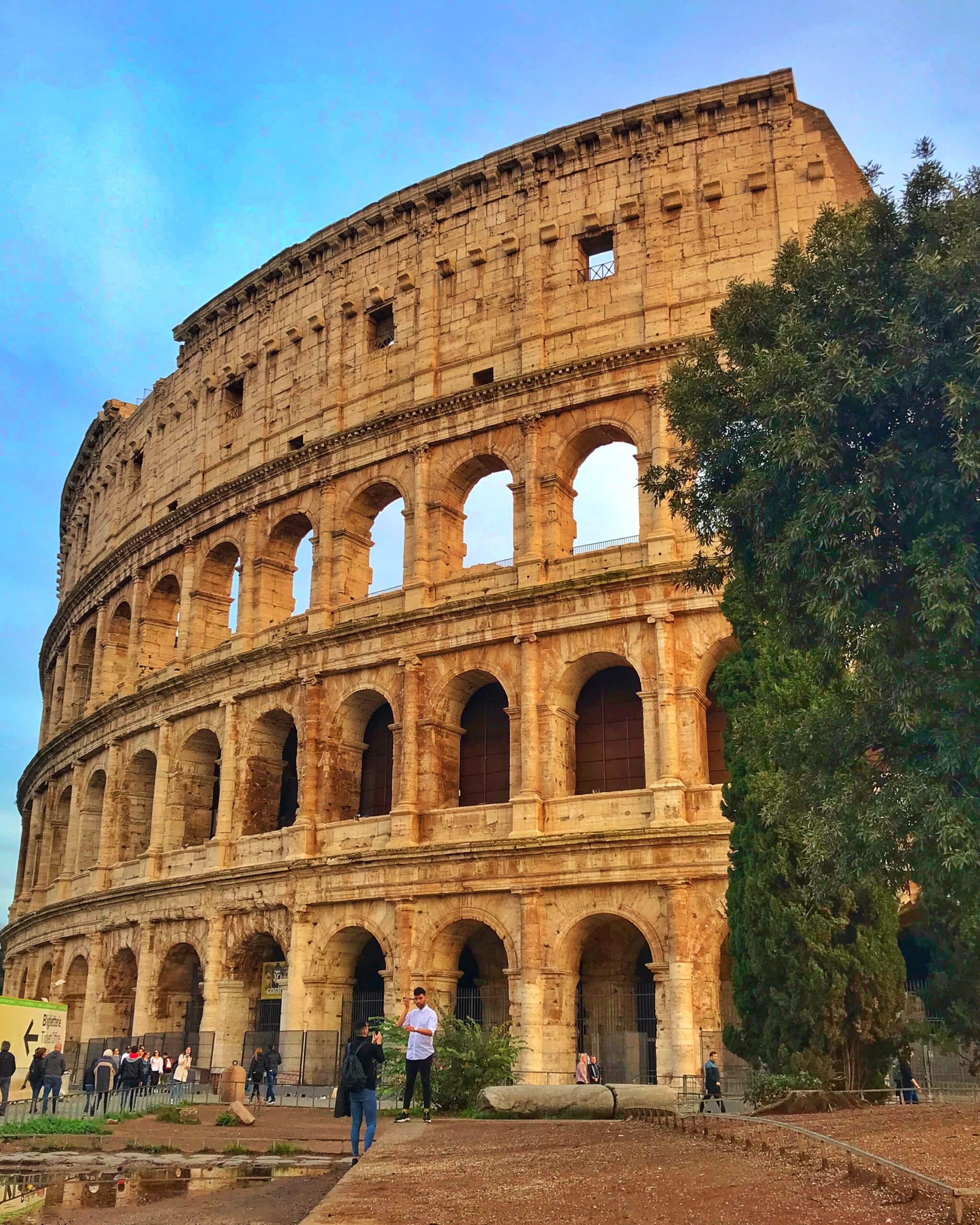 Vista del colisión Roma con turistas, haciéndose fotos al alrededor, mostrando icónico, anfiteatro romano y su arquitectura histórica impresionante