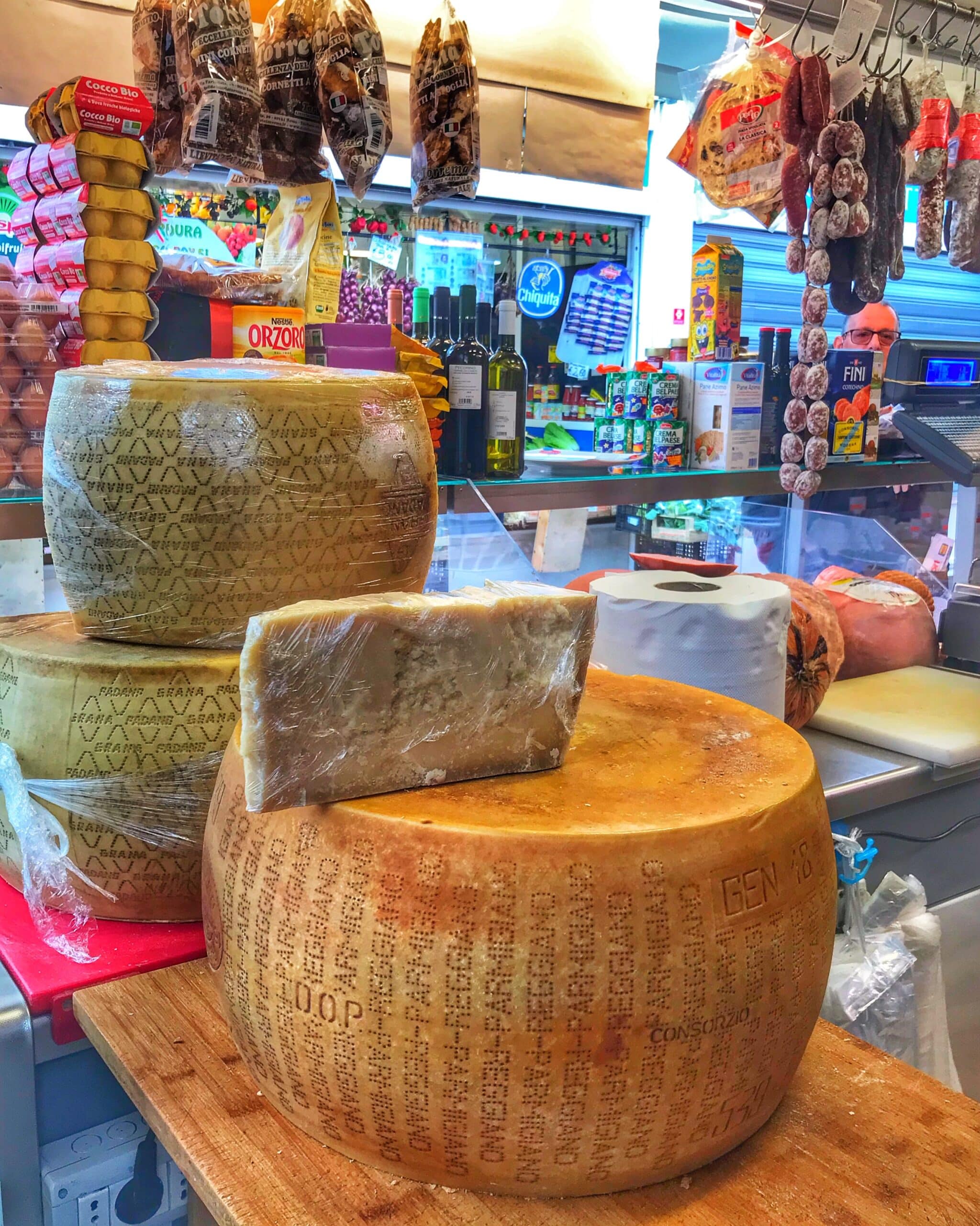 Grandes quesos, redondos, expuestos en una tienda de ropa, mostrando productos de gastronomía, italiana, tradicional y variedad de quesos artesanales