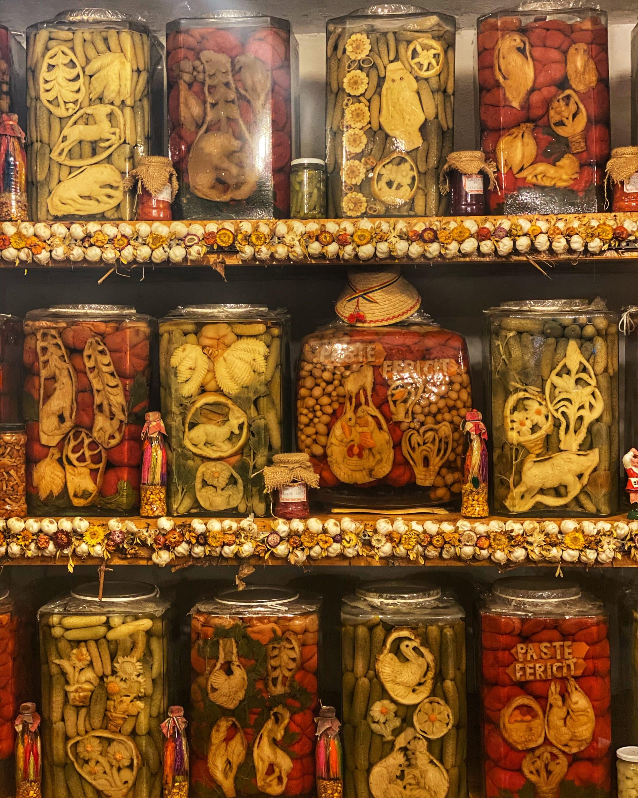 Varios tarros de cristal con encurtidos caseros típicos de Transylvania, mostrando la conservación y gastronomía rural de la región.