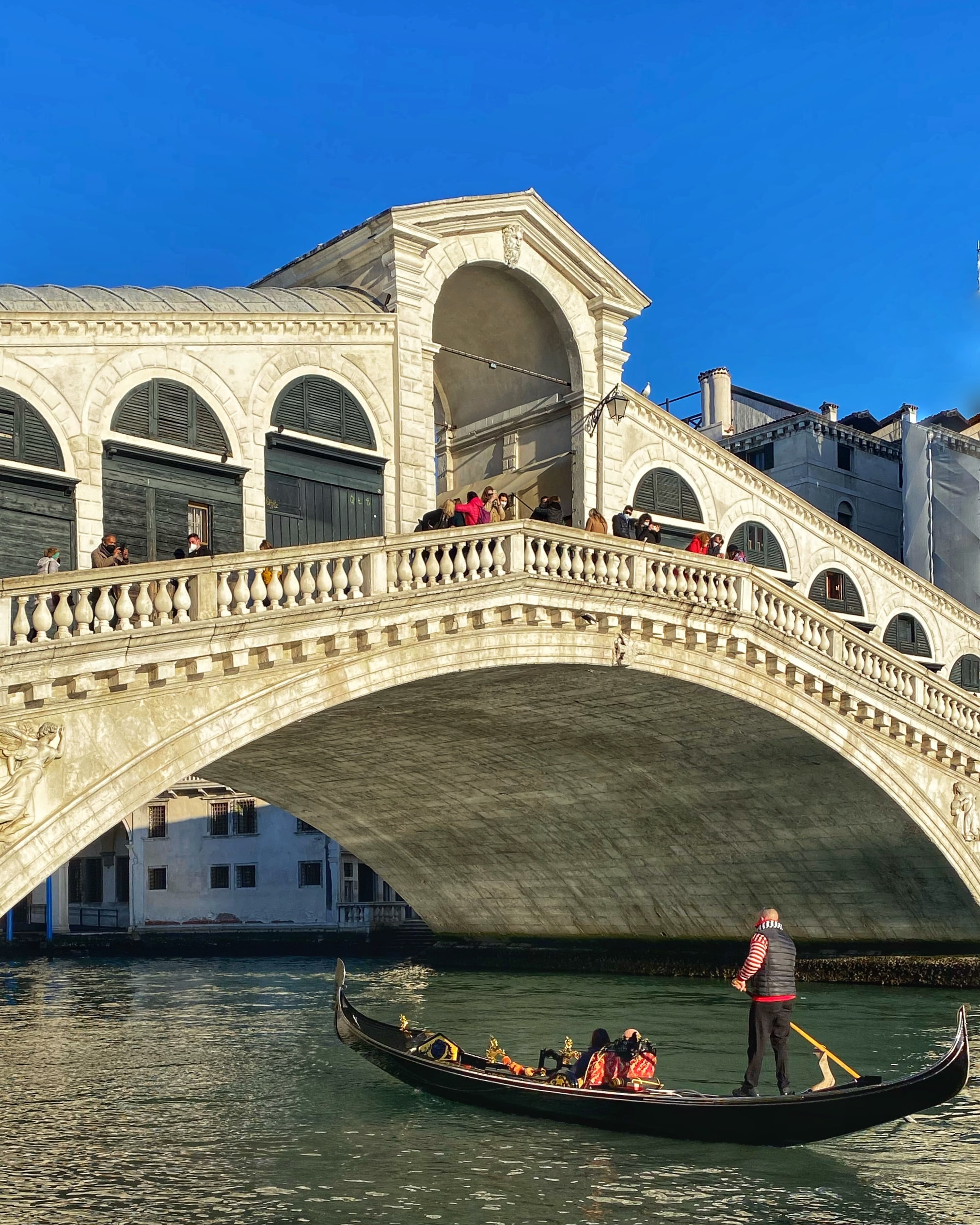 Cuando la navegando por debajo de un puente histórico, en Venecia, capturando la arquitectura y los canales típicos de la ciudad.