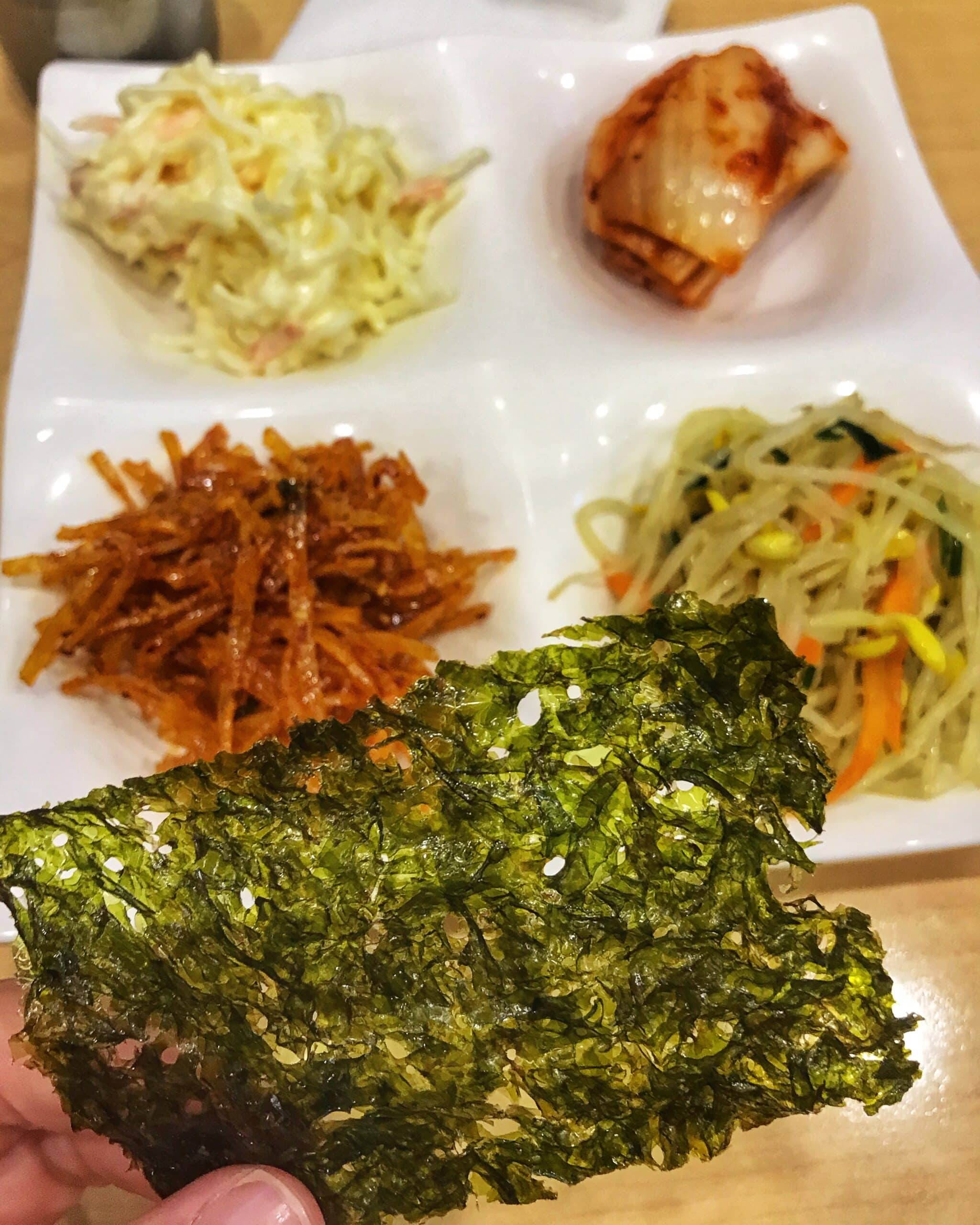 Variedad de algas y verduras frescas en un restaurante de Seúl, dispuestas para la venta, mostrando ingredientes típicos de la gastronomía coreana