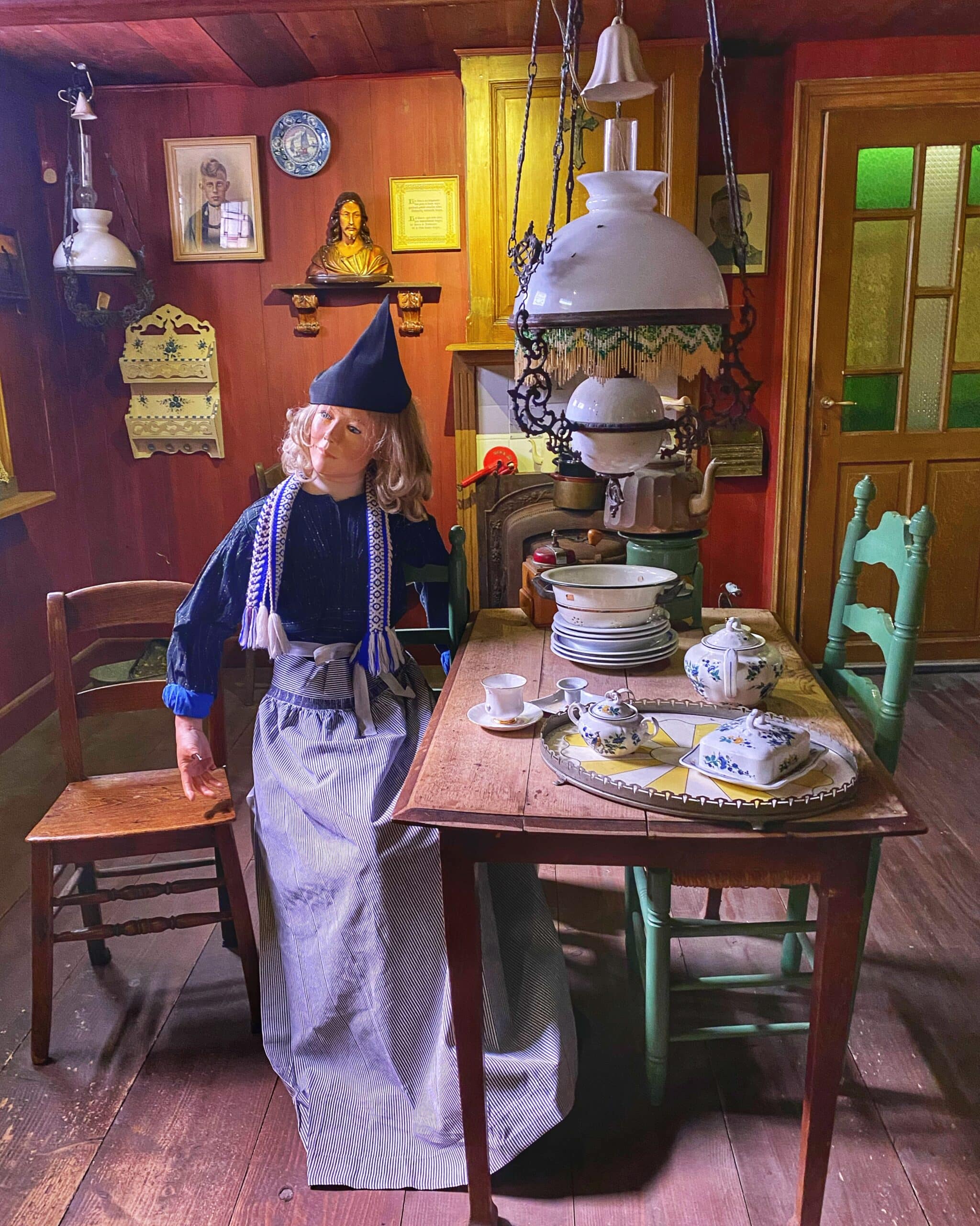 Muñeca con vestimenta tradicional en una habitación antigua de estilo holandés