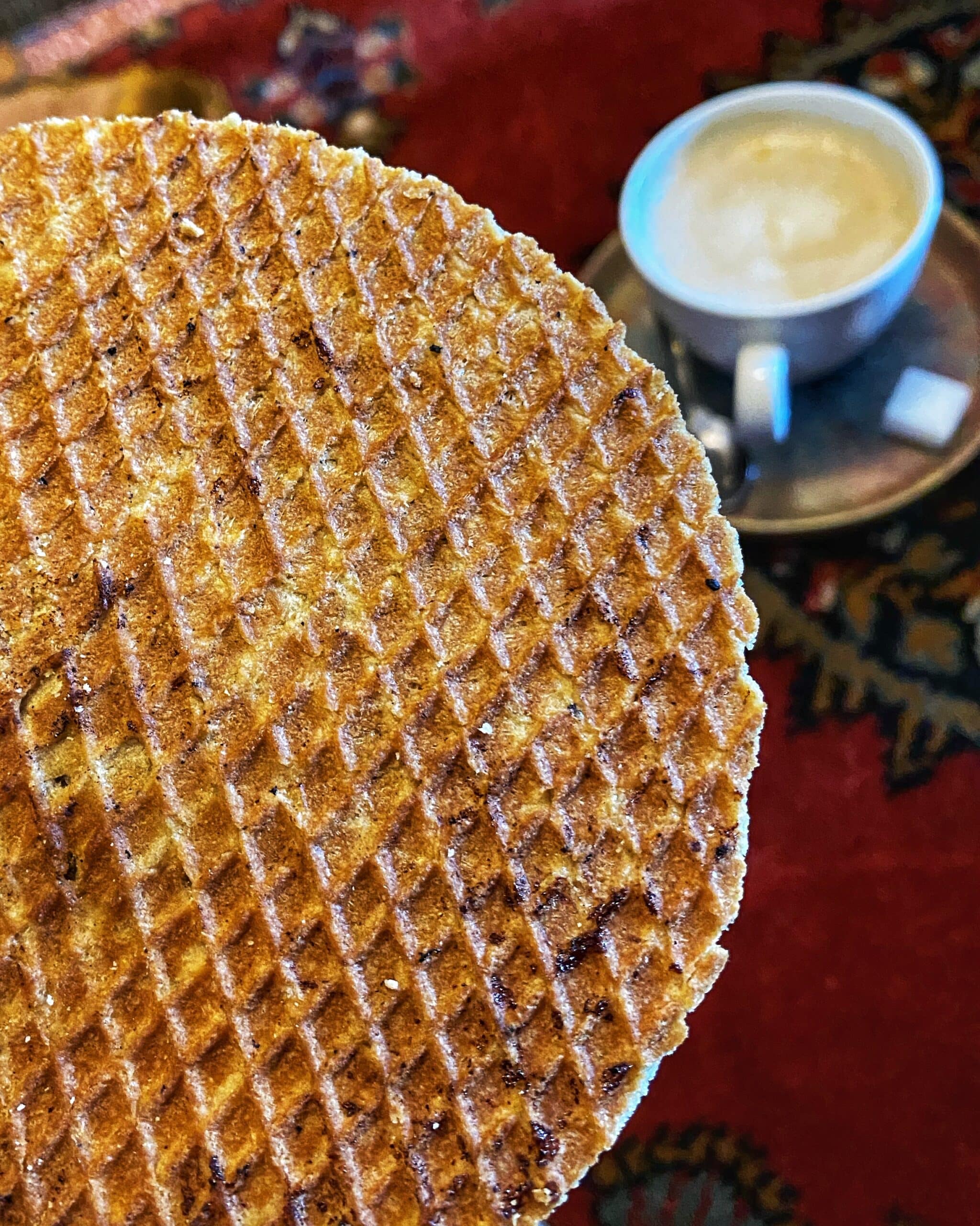 Taza de café, acompañada de una oblea dulce, en una cafetería de Ámsterdam