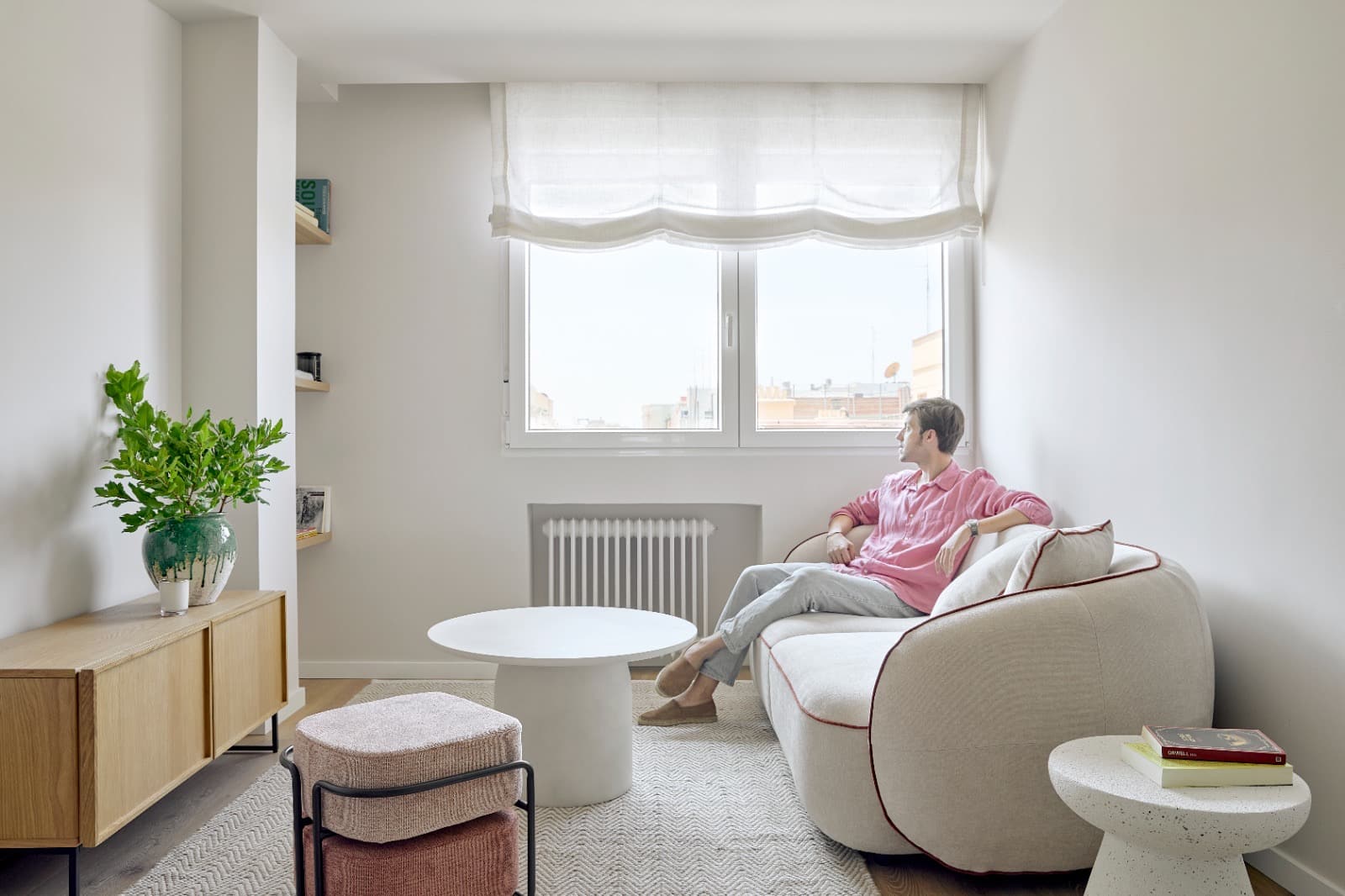Arquitecto sentado en el sofá de su casa terminada, salón de vivienda final en la serie ‘Busco Piso’, VidaViva Producciones.